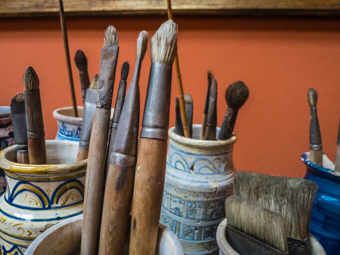 Artisan paintbrushes stored in Moroccon pots